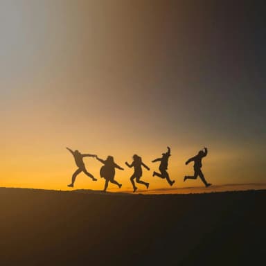 Silhouettes of people jumping at sunset